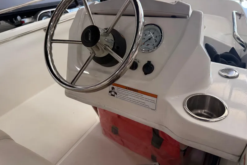 Slide: The Image of 2021 Boston Whaler 130 Super Sport steering console with stainless steel wheel and gauges. - 8