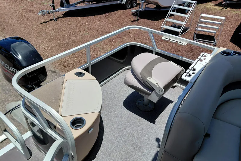 Slide: The Image of 2015 Sun Tracker Bass Buggy 18 DLX pontoon boat interior with seating and Mercury outboard motor. - 21