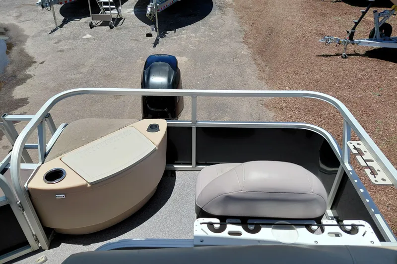 Slide: The Image of 2015 Sun Tracker Bass Buggy 18 DLX pontoon boat interior with seating and motor view. - 20