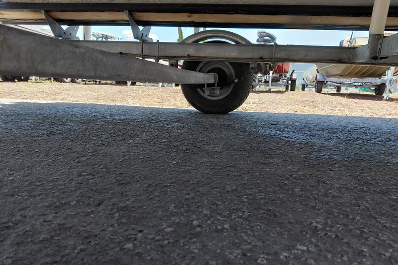 Slide: The Image of Underneath view of a 2015 Sun Tracker Bass Buggy 18 DLX trailer on pavement. - 35