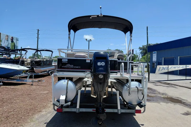 Slide: The Image of 2015 Sun Tracker Bass Buggy 18 DLX pontoon boat with 60 HP engine, parked outdoors. - 7