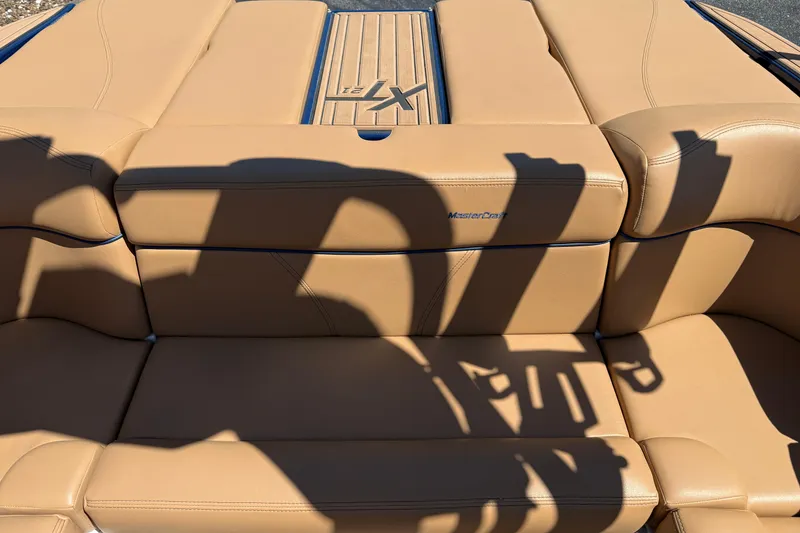 Slide: The Image of 2021 MasterCraft XT21 boat interior with tan leather seating and logo. - 16