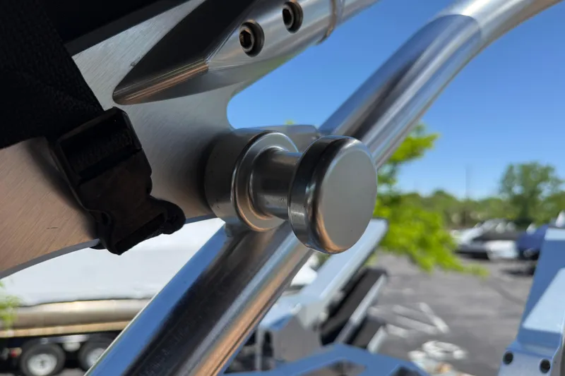 Slide: The Image of Close-up of a 2021 MasterCraft XT21 boat's metal component under a clear blue sky. - 31