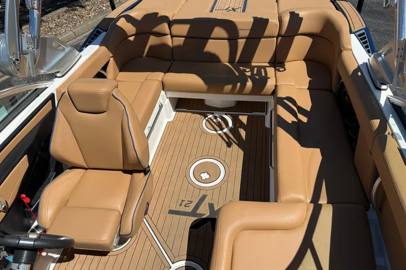 Slide: The Image of 2021 MasterCraft XT21 boat interior with tan leather seating and teak flooring. - 6