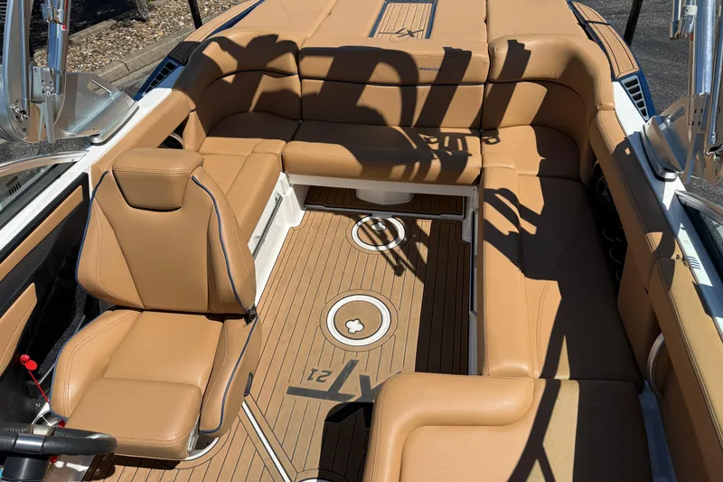 Slide: The Image of 2021 MasterCraft XT21 boat interior with tan leather seating and teak-style flooring. - 7