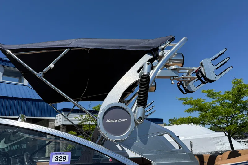 Slide: The Image of 2021 MasterCraft XT21 boat with wakeboard tower and canopy under clear blue sky. - 37