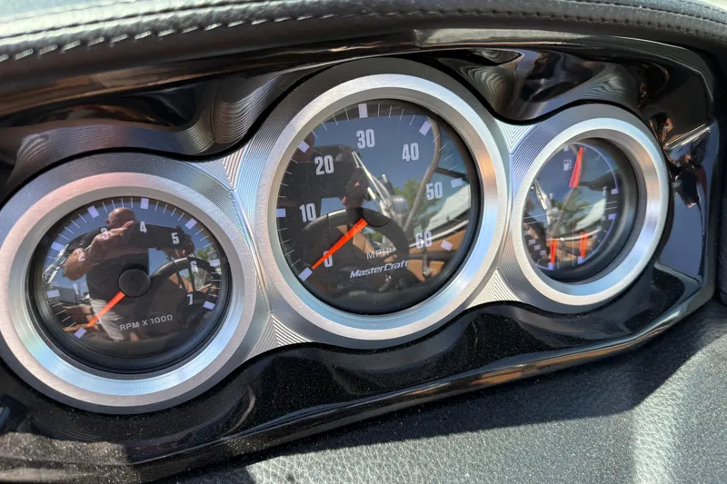 Slide: The Image of Dashboard gauges of a 2021 MasterCraft XT21 boat, showing RPM and speed. - 21