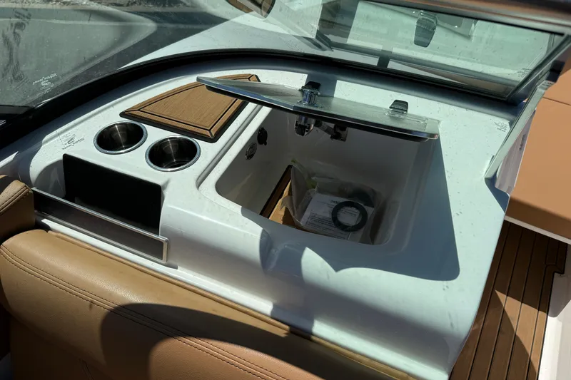 Slide: The Image of Interior of 2021 MasterCraft XT21 boat featuring cup holders and storage compartment. - 32