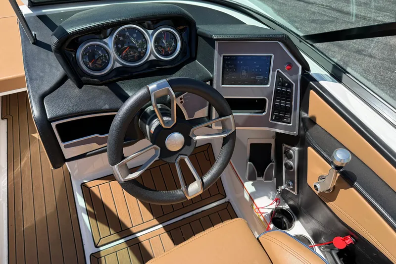 Slide: The Image of 2021 MasterCraft XT21 boat dashboard with steering wheel, gauges, and control panel. - 11