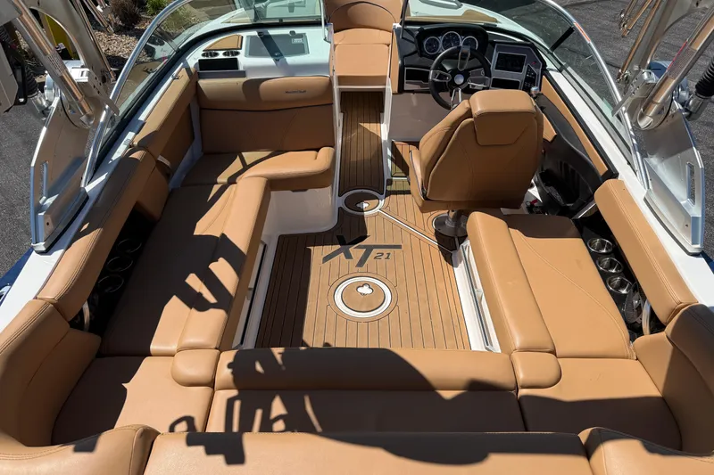 Slide: The Image of 2021 MasterCraft XT21 boat interior with tan seating and sleek dashboard design. - 27