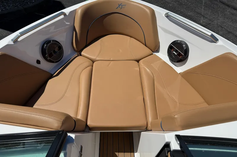 Slide: The Image of 2021 MasterCraft XT21 boat interior with tan leather seating and built-in speakers. - 4