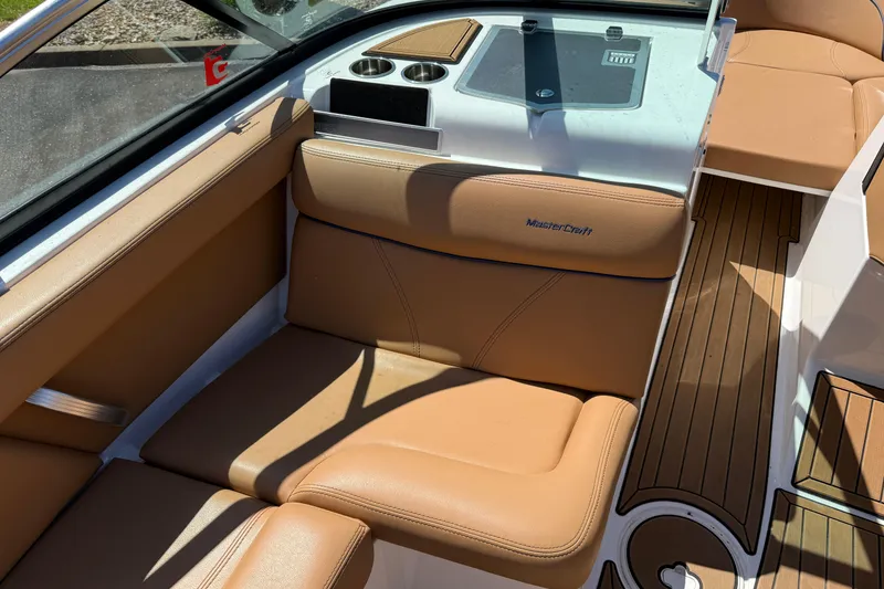 Slide: The Image of 2021 MasterCraft XT21 boat interior with tan leather seats and wood flooring. - 13