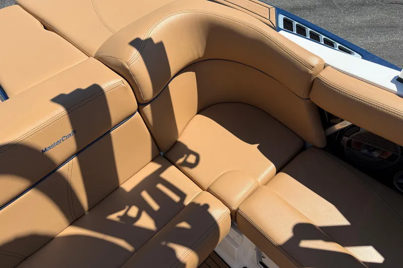 Slide: The Image of 2021 MasterCraft XT21 boat with tan leather seating and shadow patterns. - 15
