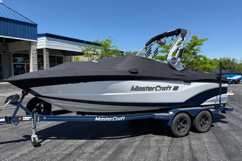 Slide: The Image of 2021 MasterCraft XT21 boat on trailer, covered, parked outside dealership. - 44
