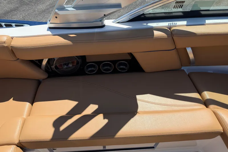 Slide: The Image of 2021 MasterCraft XT21 boat interior with tan leather seating and speaker system. - 14