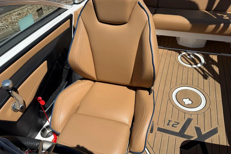 Slide: The Image of 2021 MasterCraft XT21 boat interior with tan leather seat and custom flooring. - 8
