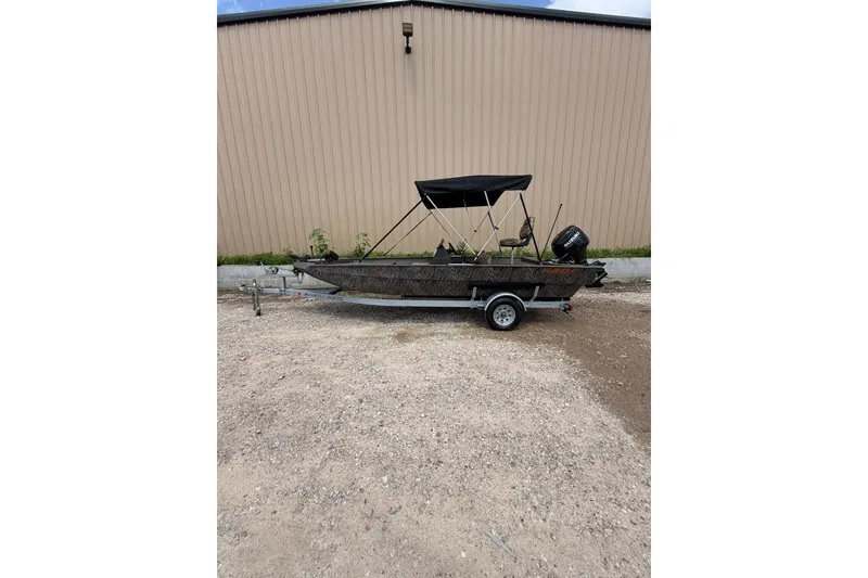 The Image of 2024 Alweld 1856 Invader boat with canopy on trailer, parked outdoors. - 1