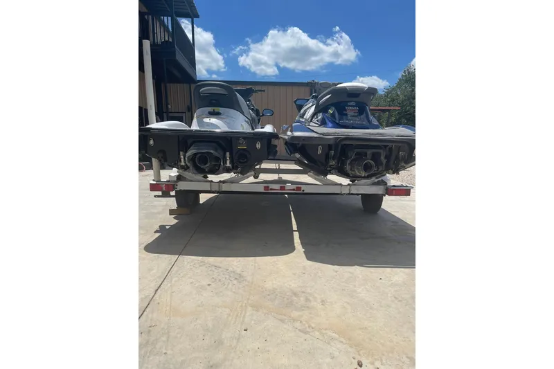 Slide: The Image of Two Yamaha VX-Deluxe jet skis on a trailer, parked outdoors under a sunny sky. - 5