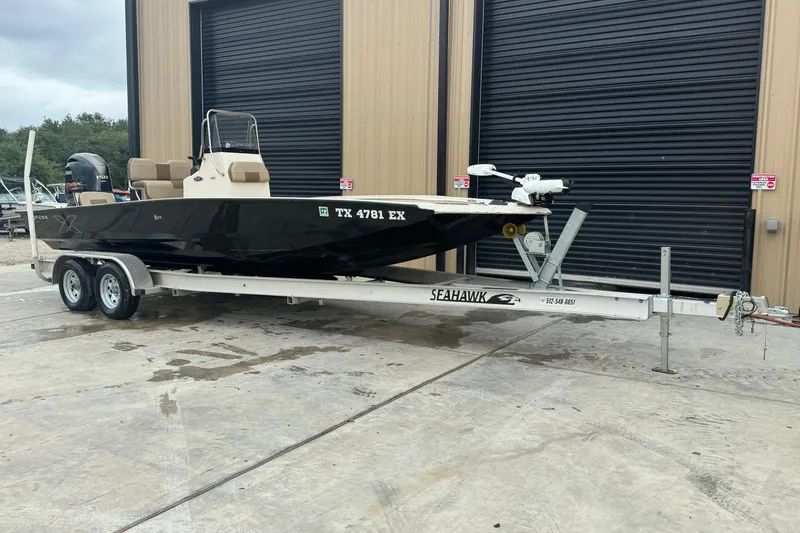 Slide: The Image of 2020 Xpress H22B Bay boat on trailer, parked outside a building. - 2
