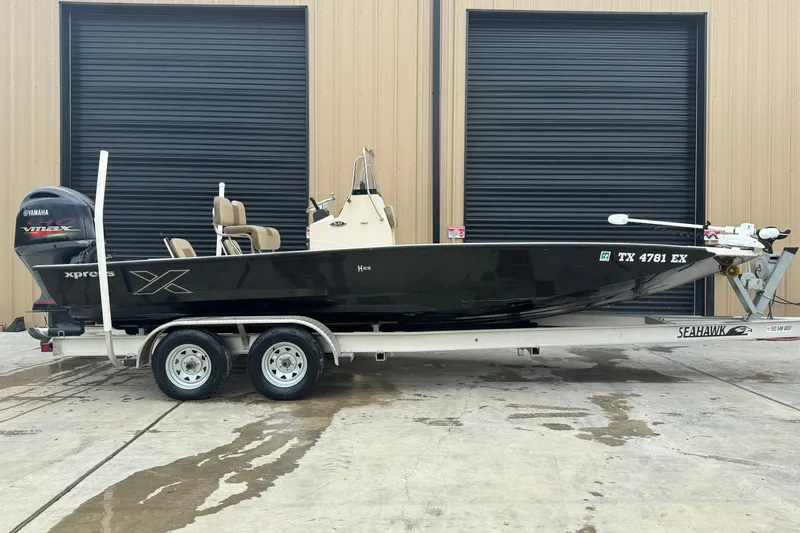 Slide: The Image of 2020 Xpress H22B Bay boat on trailer, parked outside a building. - 4