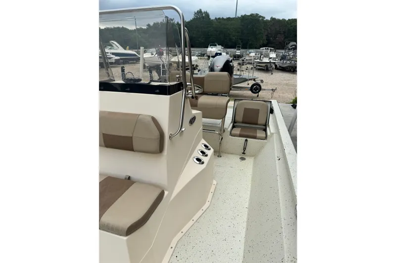 Slide: The Image of 2020 Xpress H22B Bay boat interior with beige seating and console, parked outdoors. - 15