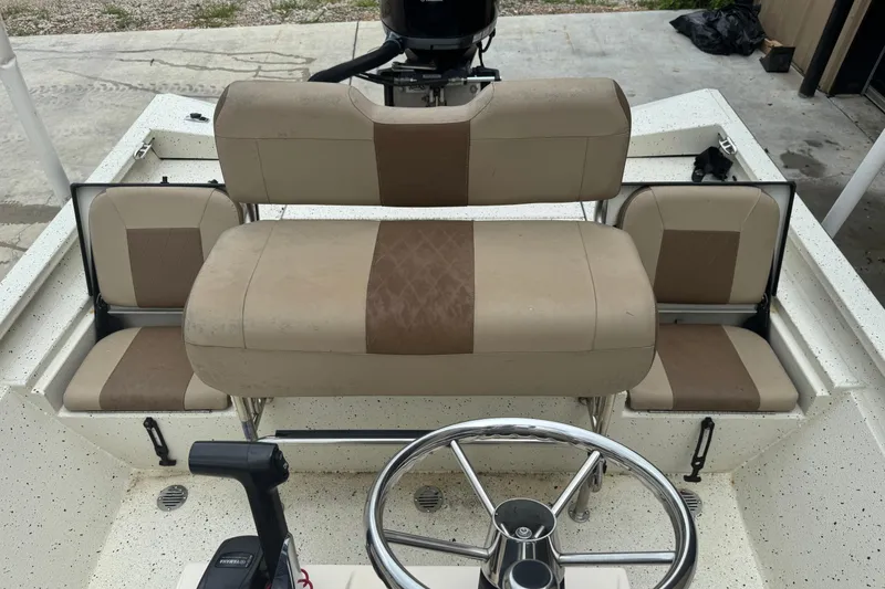 Slide: The Image of 2020 Xpress H22B Bay boat interior with beige seating and steering wheel. - 16