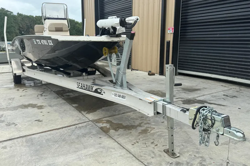 Slide: The Image of 2020 Xpress H22B Bay boat on trailer, parked outside a garage. - 3