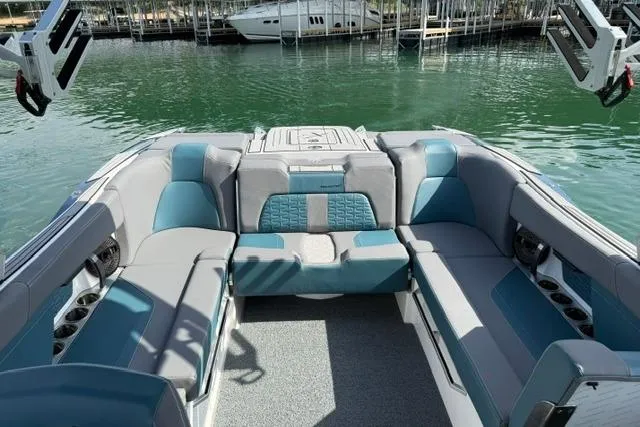 Slide: The Image of 2025 MasterCraft X24 boat interior with spacious seating and modern design on a calm lake. - 13