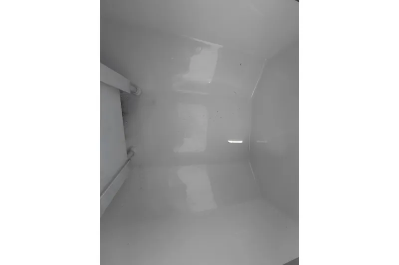 Slide: The Image of Interior view of 2023 Pioneer 220 Bay Sport boat compartment, showcasing clean, white finish. - 21