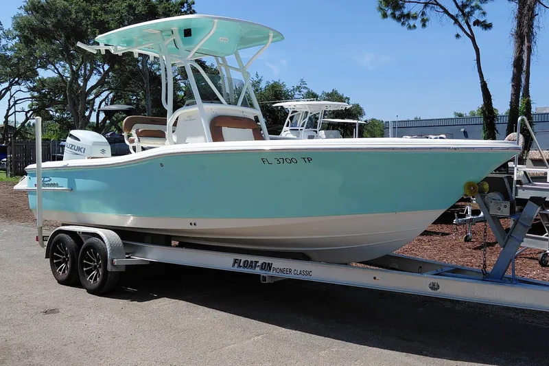 The Image of 2023 Pioneer 220 Bay Sport boat on trailer, light blue hull, parked outdoors. - 1