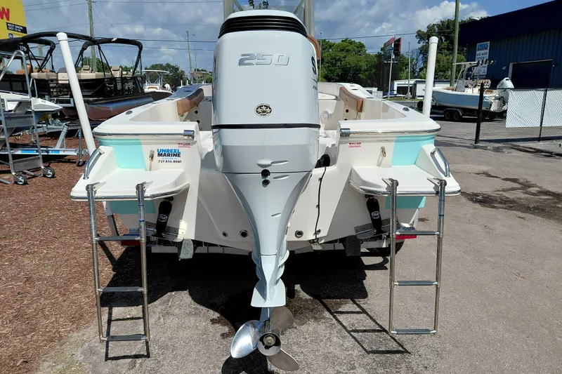 Slide: The Image of 2023 Pioneer 220 Bay Sport boat with powerful outboard motor, displayed at a marine dealership. - 62