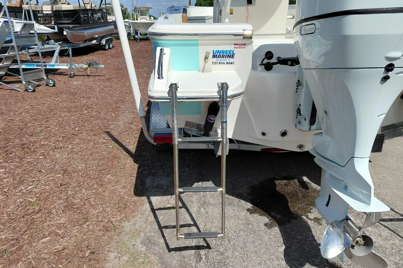 Slide: The Image of 2023 Pioneer 220 Bay Sport boat with ladder and outboard motor at a marina. - 61