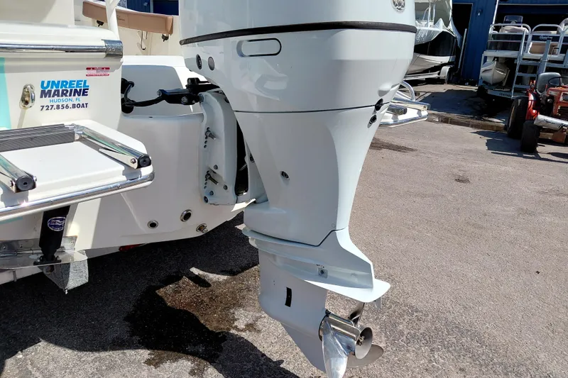 Slide: The Image of 2023 Pioneer 220 Bay Sport boat with outboard motor in a marina setting. - 59