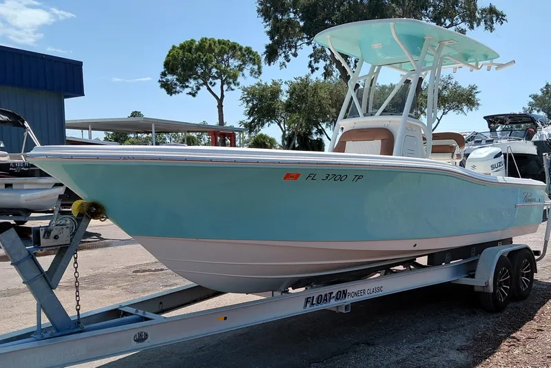 Slide: The Image of 2023 Pioneer 220 Bay Sport boat on trailer, light blue hull, parked outdoors. - 3