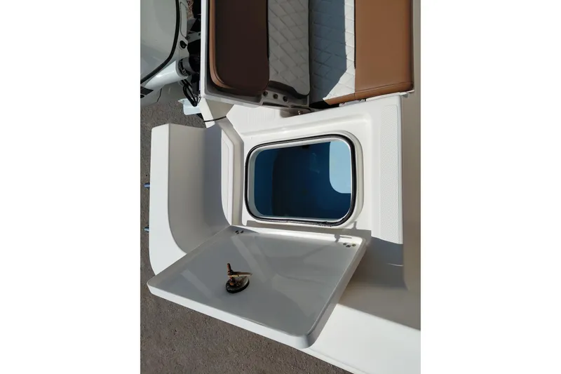 Slide: The Image of 2023 Pioneer 220 Bay Sport boat storage compartment with open hatch and seating area. - 44