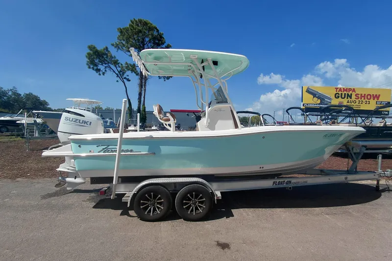 Slide: The Image of 2023 Pioneer 220 Bay Sport boat on trailer, displayed outdoors under clear blue sky. - 7