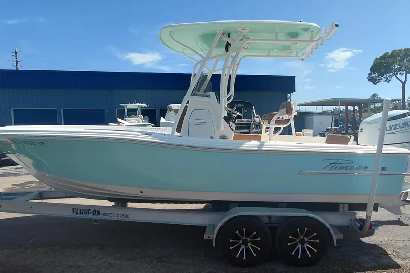 Slide: The Image of 2023 Pioneer 220 Bay Sport boat on trailer, light blue hull, outdoor setting. - 4