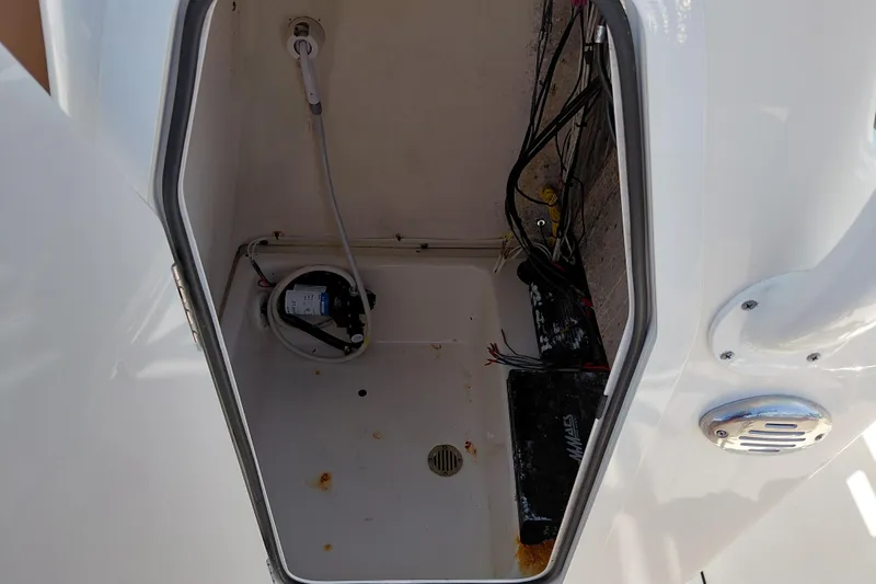 Slide: The Image of 2023 Pioneer 220 Bay Sport boat compartment with wiring and pump system. - 31