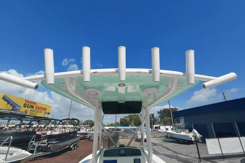 Slide: The Image of 2023 Pioneer 220 Bay Sport boat with rod holders, under a clear blue sky. - 46