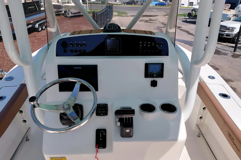 Slide: The Image of 2023 Pioneer 220 Bay Sport boat dashboard with steering wheel and navigation controls. - 35