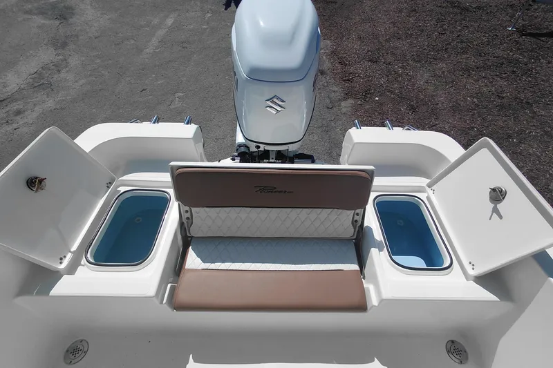 Slide: The Image of 2023 Pioneer 220 Bay Sport boat with open storage compartments and outboard motor. - 45