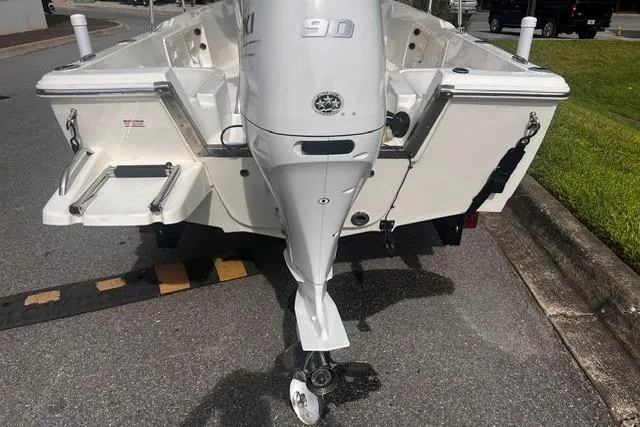 Slide: The Image of 2024 Key West 1720 Center Console boat with Suzuki 90 engine, parked on pavement. - 3