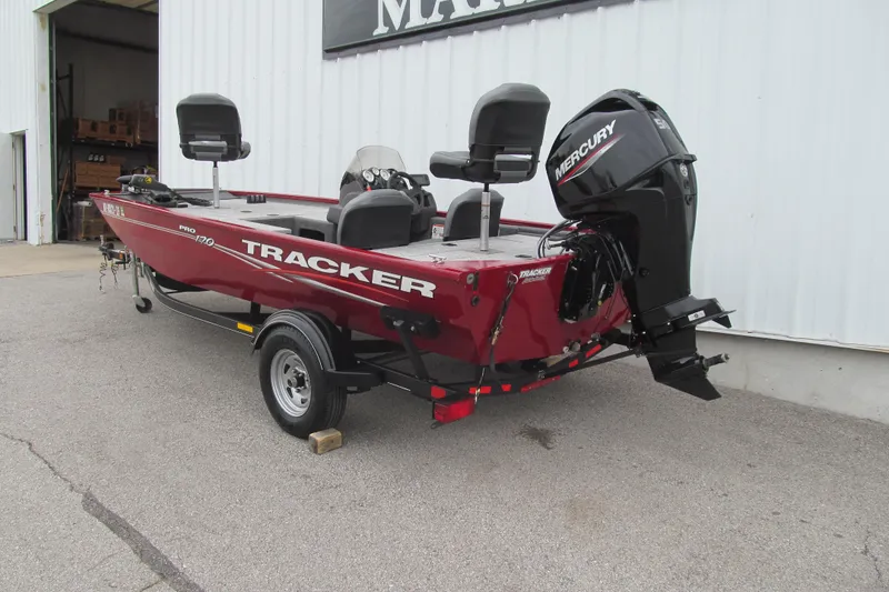 Slide: The Image of 2020 Tracker Pro 170 boat with Mercury engine, parked outside a building. - 2