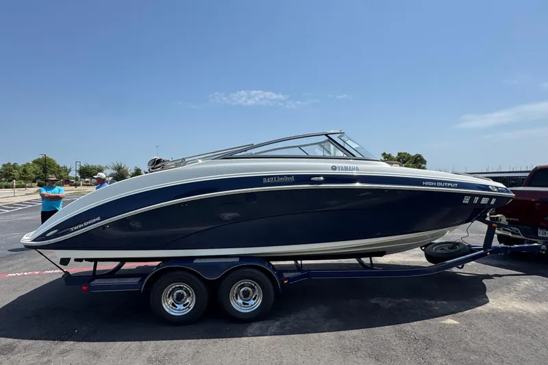 Slide: The Image of 2011 Yamaha Boats 242 Limited on trailer in parking lot under clear blue sky. - 25
