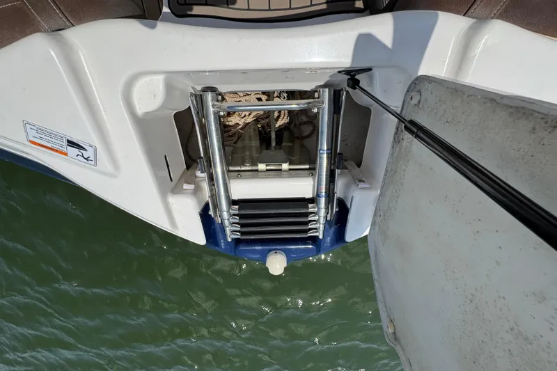 Slide: The Image of 2011 Yamaha Boats 242 Limited swim platform with retractable ladder over water. - 13