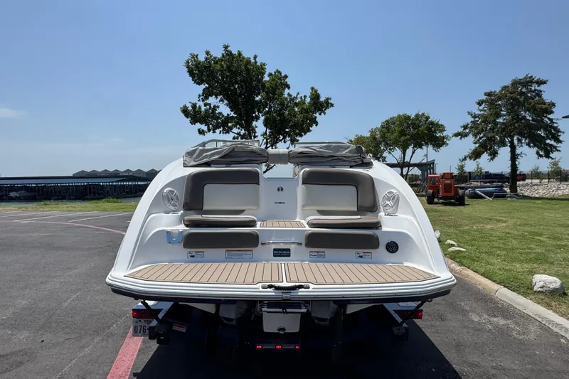 Slide: The Image of 2011 Yamaha Boats 242 Limited, rear view, parked on pavement near grassy area. - 24