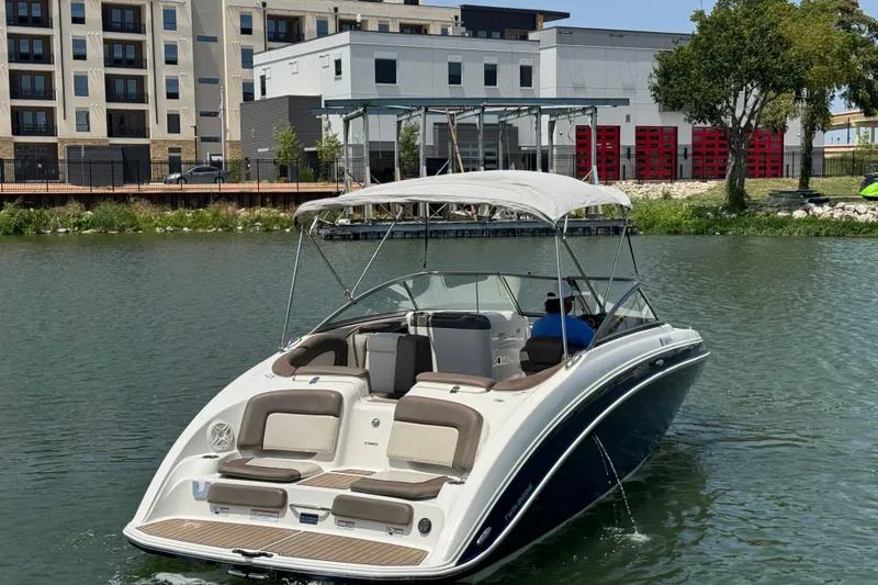 Slide: The Image of 2011 Yamaha Boats 242 Limited on water near modern buildings and greenery. - 6