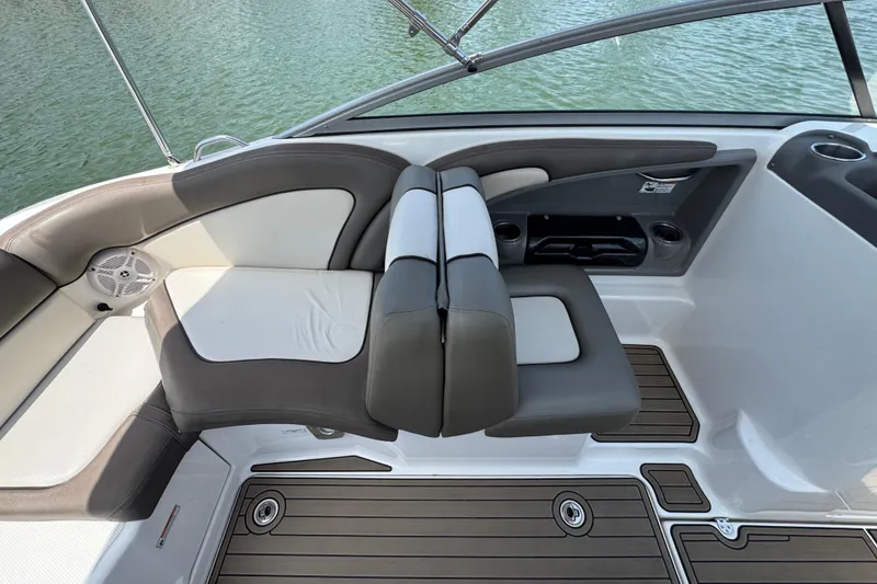 Slide: The Image of 2011 Yamaha Boats 242 Limited interior with cushioned seating and cup holders on a lake. - 19
