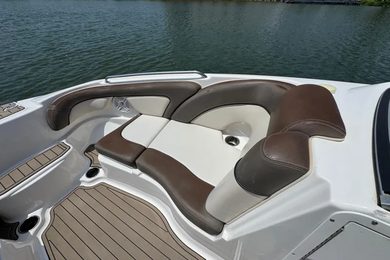 Slide: The Image of 2011 Yamaha Boats 242 Limited interior with brown and white seating, on calm water. - 11