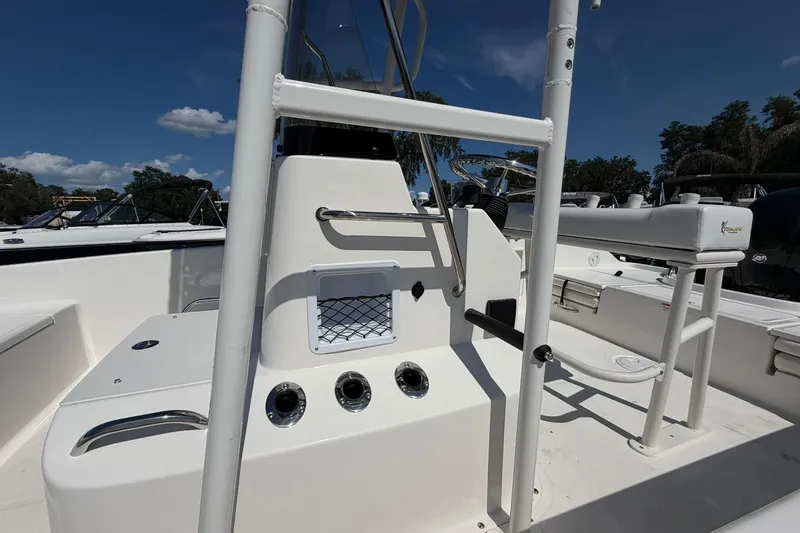 Slide: The Image of 2025 Bayliner Trophy T18 boat interior with seating and console under clear blue sky. - 16